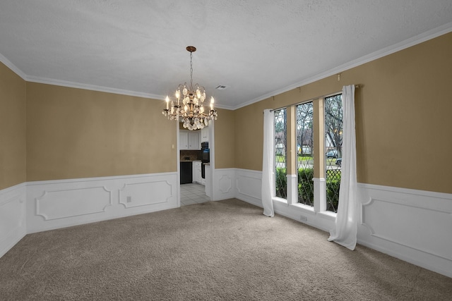 unfurnished dining area featuring wainscoting, light carpet, a decorative wall, a chandelier, and ornamental molding