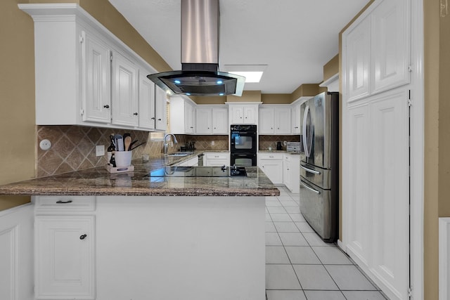 kitchen featuring island exhaust hood, a sink, white cabinets, black appliances, and a peninsula