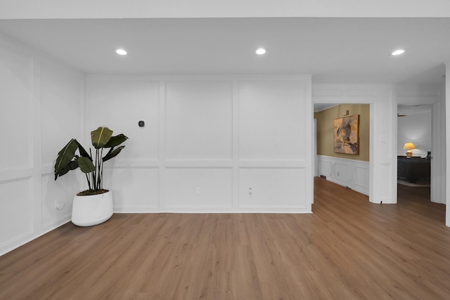 interior space with recessed lighting, light wood-type flooring, and a decorative wall