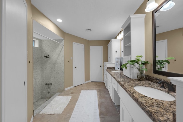 full bathroom featuring a sink, a walk in shower, double vanity, and visible vents