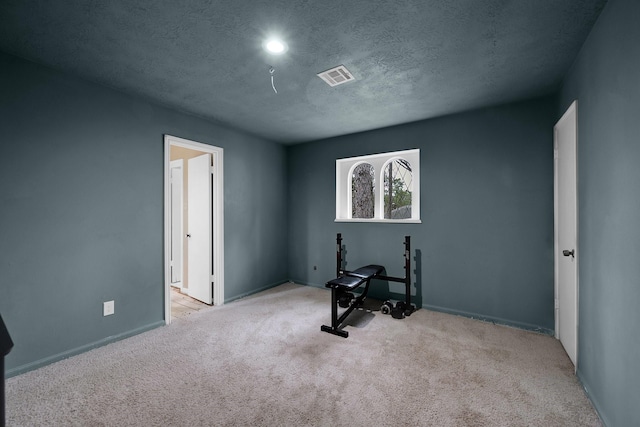 workout room featuring baseboards, carpet flooring, a textured ceiling, and visible vents