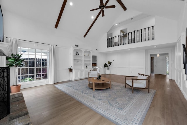 living room featuring visible vents, wood finished floors, beamed ceiling, ceiling fan, and high vaulted ceiling