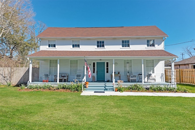 country-style home with a porch, fence, and a front lawn