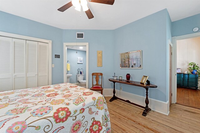 bedroom featuring connected bathroom, a closet, light wood-style flooring, and visible vents