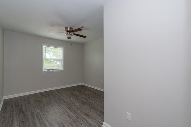 unfurnished room with baseboards, dark wood-style flooring, ceiling fan, and visible vents