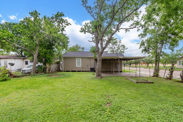 view of yard featuring fence, a carport, and cooling unit