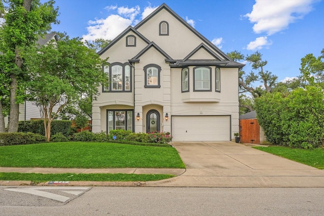 919 Worthshire St, Houston, TX 77008 - french provincial home featuring an attached garage, stucco siding, fence, concrete driveway, and a front lawn