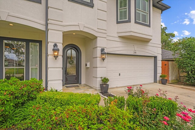 919 Worthshire St, Houston, TX 77008 - doorway to property with an attached garage, driveway, and stucco siding
