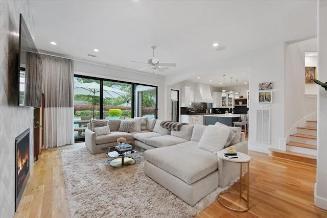 919 Worthshire St, Houston, TX 77008 - living room with a ceiling fan, light wood finished floors, a lit fireplace, recessed lighting, and stairs