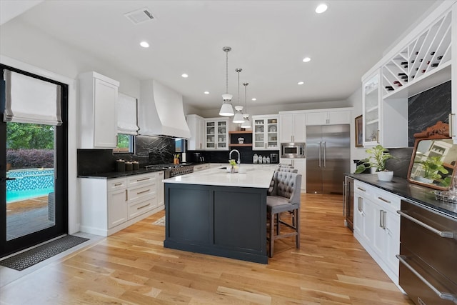 919 Worthshire St, Houston, TX 77008 - kitchen featuring built in appliances, custom exhaust hood, tasteful backsplash, recessed lighting, and white cabinetry