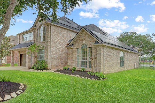 view of property exterior featuring roof mounted solar panels, fence, a yard, and brick siding