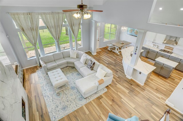 living area featuring recessed lighting, baseboards, ceiling fan, and light wood-type flooring