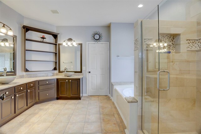 full bathroom with visible vents, a garden tub, double vanity, a shower stall, and a sink