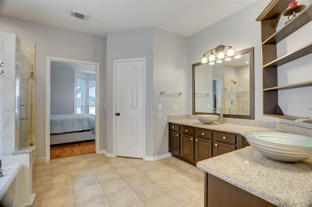 bathroom featuring visible vents, a shower stall, and a sink