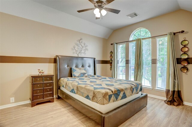 bedroom featuring baseboards, lofted ceiling, wood finished floors, and visible vents
