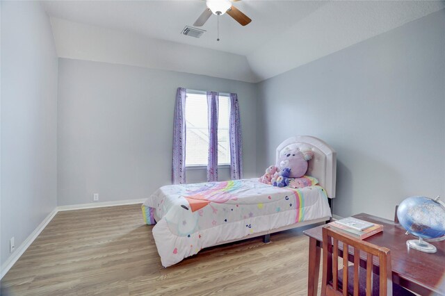 bedroom with visible vents, baseboards, lofted ceiling, and light wood-type flooring