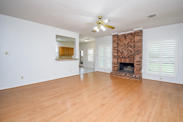 6007 Gideon Ct, Sugar Land, TX 77479 - unfurnished living room with ceiling fan, visible vents, a brick fireplace, baseboards, and light wood finished floors