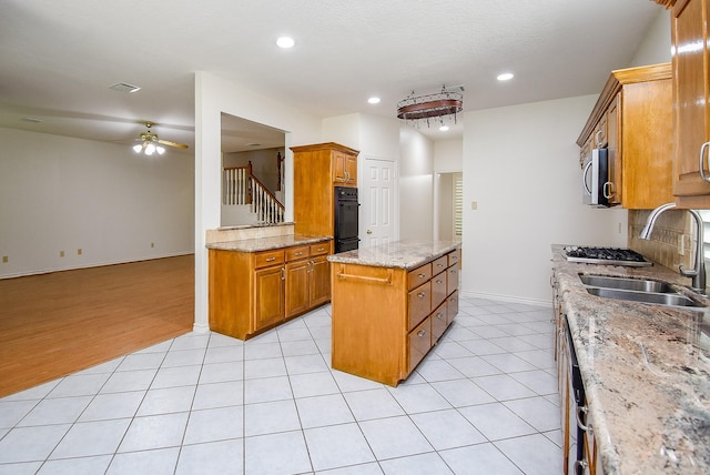6007 Gideon Ct, Sugar Land, TX 77479 - kitchen with ceiling fan, a sink, brown cabinetry, baseboards, and a kitchen island