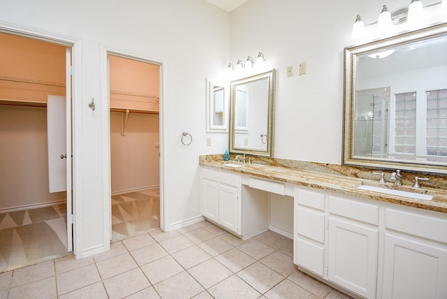 6007 Gideon Ct, Sugar Land, TX 77479 - bathroom featuring a sink, tile patterned floors, a tile shower, and double vanity