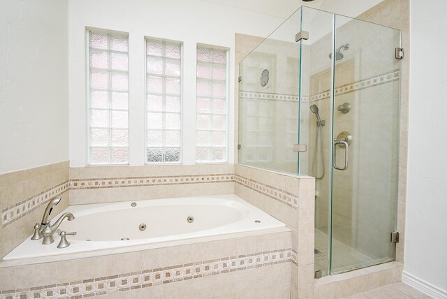 full bathroom featuring tile patterned floors, a whirlpool tub, and a stall shower