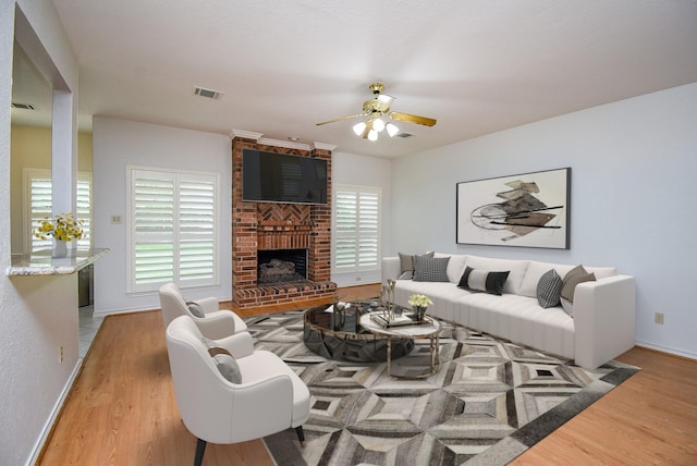 6007 Gideon Ct, Sugar Land, TX 77479 - living area with visible vents, ceiling fan, a fireplace, and light wood-type flooring