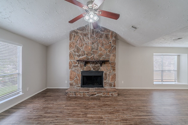 unfurnished living room featuring vaulted ceiling, a textured ceiling, and wood finished floors