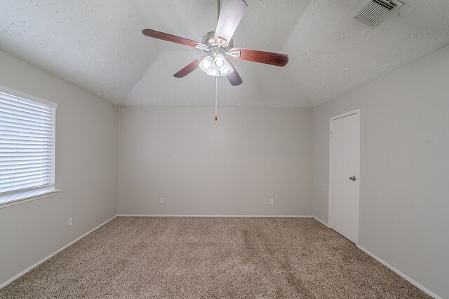 carpeted spare room featuring baseboards, ceiling fan, a textured ceiling, and visible vents