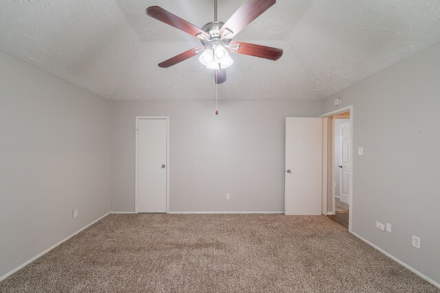 empty room featuring carpet flooring, a textured ceiling, baseboards, and ceiling fan