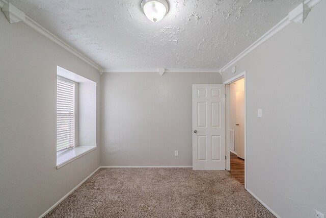 empty room with carpet flooring, a textured ceiling, and ornamental molding