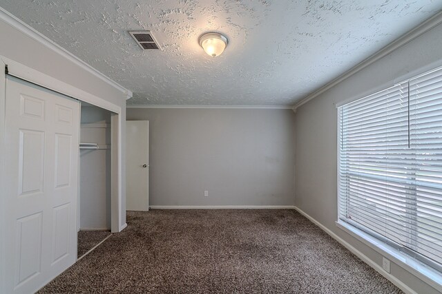 unfurnished bedroom with visible vents, carpet, and multiple windows