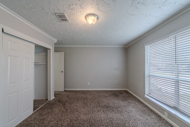 20211 Big Timber Ct, Humble, TX 77346 - unfurnished bedroom with carpet, multiple windows, a closet, a textured ceiling, and ornamental molding