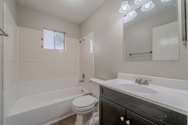 full bathroom with vanity, shower / bathtub combination, wood finished floors, toilet, and a textured ceiling