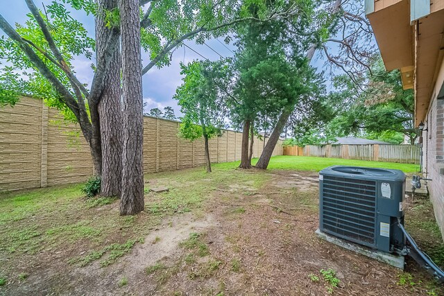 view of yard with a fenced backyard and central AC