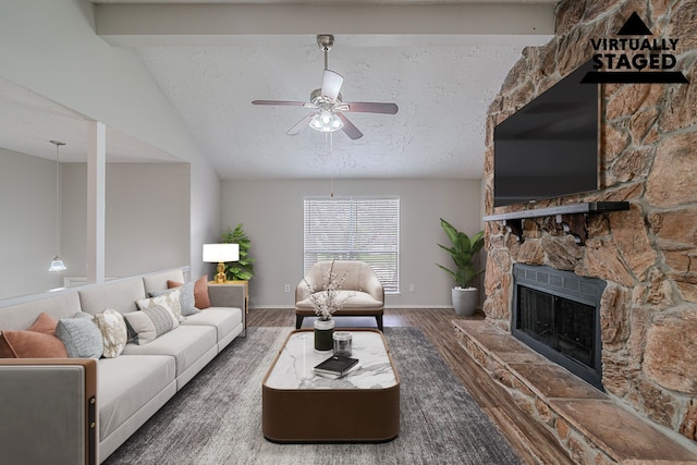20211 Big Timber Ct, Humble, TX 77346 - living room featuring wood finished floors, ceiling fan, a stone fireplace, a textured ceiling, and baseboards