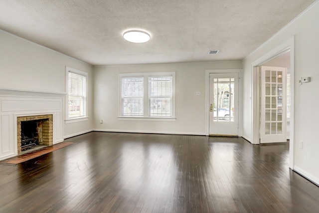 1106 Key St, Houston, TX 77009 - unfurnished living room with a textured ceiling, plenty of natural light, dark wood-style floors, a fireplace with flush hearth, and baseboards