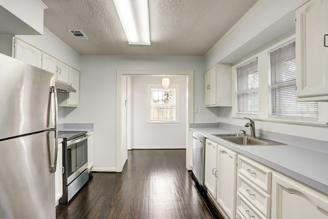 1106 Key St, Houston, TX 77009 - kitchen featuring appliances with stainless steel finishes, a sink, a textured ceiling, light countertops, and under cabinet range hood