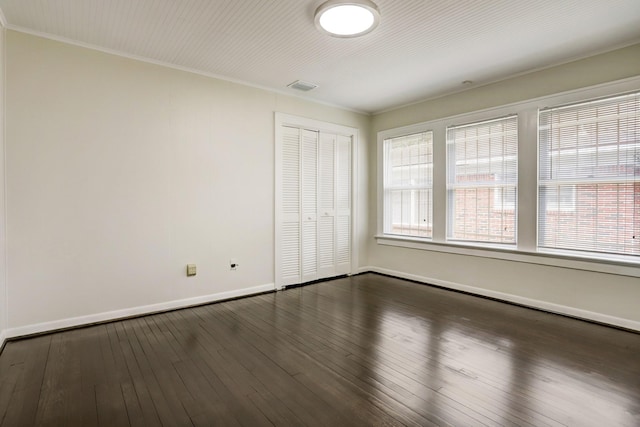 1106 Key St, Houston, TX 77009 - unfurnished bedroom featuring baseboards, a closet, crown molding, and dark wood-type flooring
