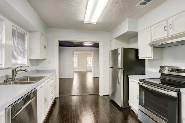 1106 Key St, Houston, TX 77009 - kitchen featuring stainless steel appliances, a sink, light countertops, white cabinetry, and a textured ceiling