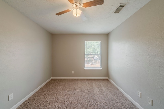 carpeted empty room with baseboards, ceiling fan, and visible vents