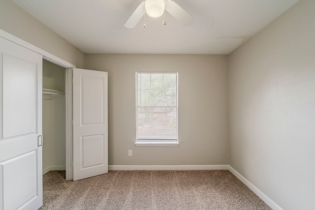 unfurnished bedroom with baseboards, ceiling fan, a closet, and light colored carpet