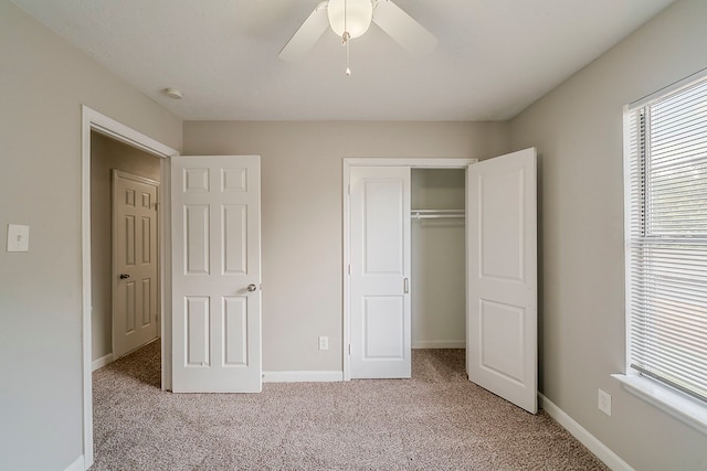unfurnished bedroom featuring a ceiling fan, baseboards, light colored carpet, and a closet