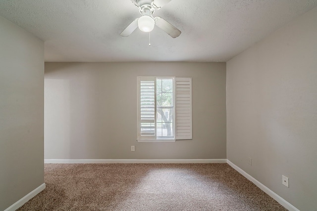 carpeted spare room with baseboards, a textured ceiling, and ceiling fan