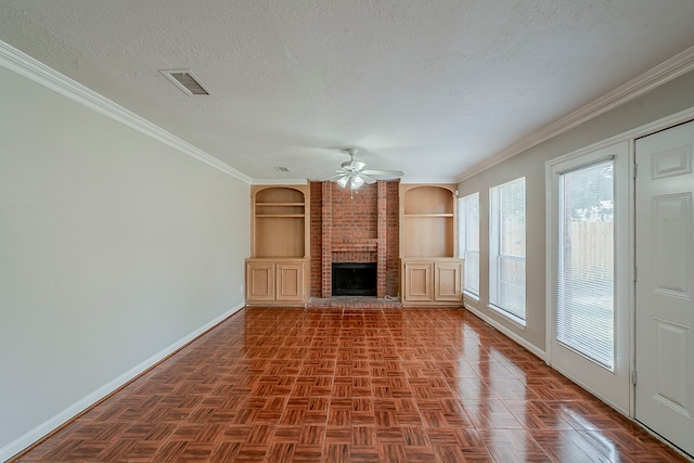 unfurnished living room featuring a brick fireplace, built in shelves, a ceiling fan, baseboards, and visible vents