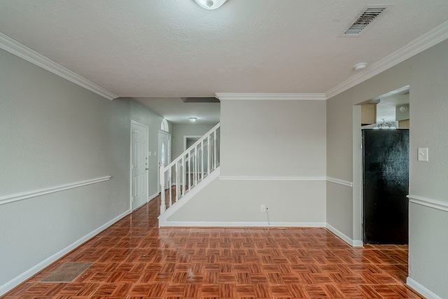 spare room with crown molding, baseboards, and visible vents