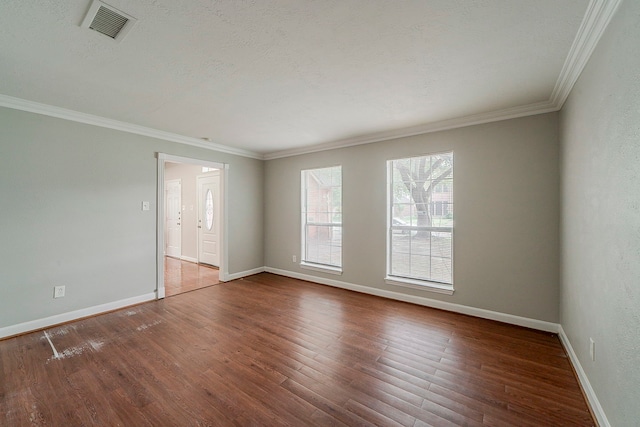 unfurnished room with baseboards, visible vents, ornamental molding, and wood finished floors