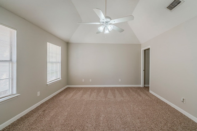 spare room featuring ceiling fan, vaulted ceiling, light colored carpet, and visible vents