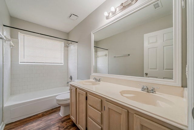 full bath with visible vents, a sink, wood finished floors, and toilet
