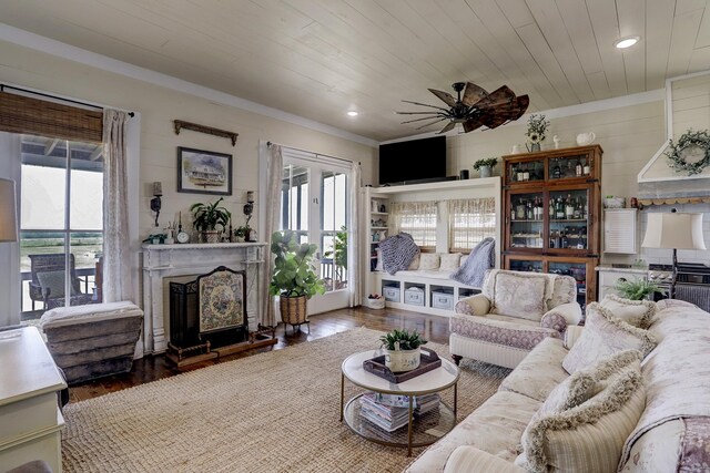 living room with wood finished floors, recessed lighting, a fireplace with raised hearth, wood ceiling, and a ceiling fan