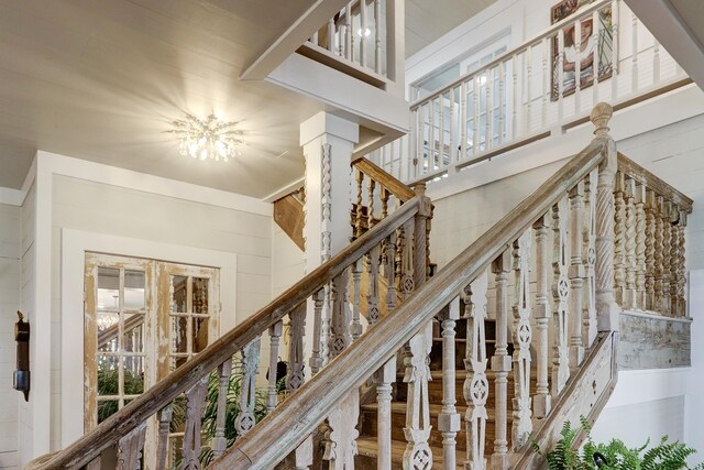 stairway with an inviting chandelier and a high ceiling