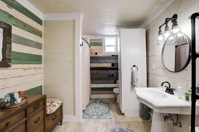 full bathroom with toilet, shower / bathtub combination with curtain, and wood finished floors